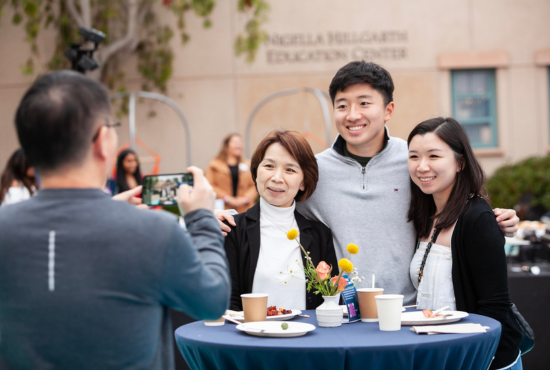 Parents of new UC San Diego student wearing UCSD shirts and smiling.