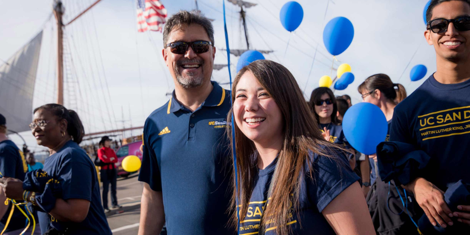 UC San Diego family smiling at the camera.